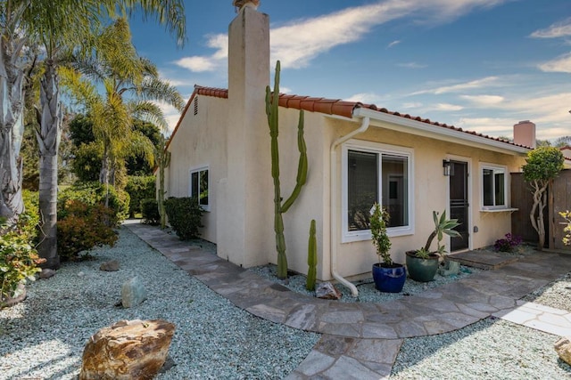 6462 Camino Del Parque, Carlsbad, CA 92011 - view of side of property with a chimney, stucco siding, and a tile roof