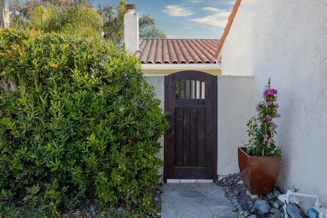 6462 Camino Del Parque, Carlsbad, CA 92011 - property entrance with stucco siding, a tile roof, a gate, and a chimney