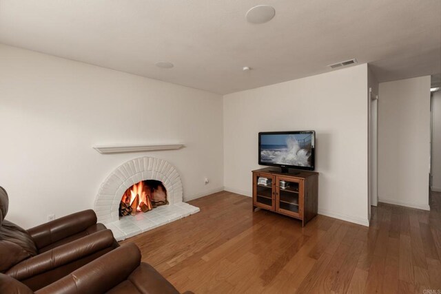 6462 Camino Del Parque, Carlsbad, CA 92011 - living area featuring wood finished floors and a brick fireplace
