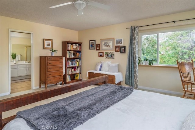bedroom featuring a ceiling fan, baseboards, a textured ceiling, and connected bathroom
