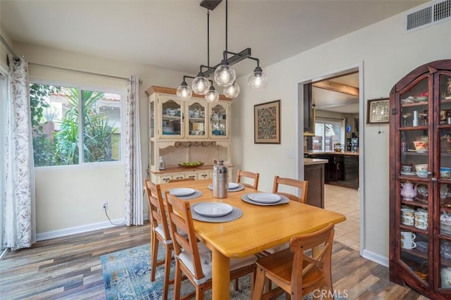 dining room featuring wood finished floors, visible vents, and baseboards