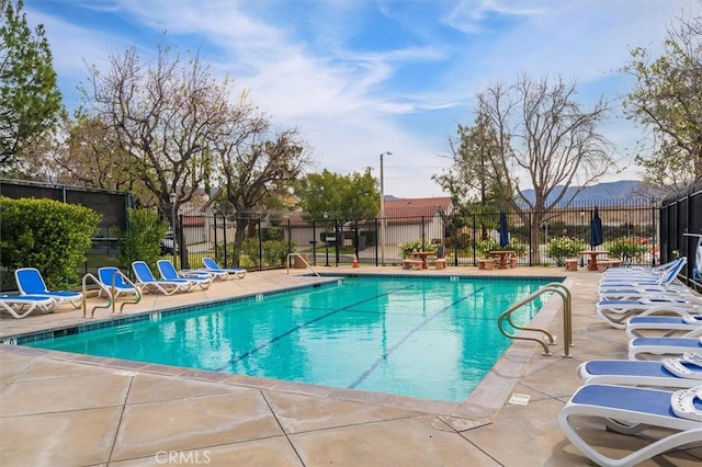 community pool featuring fence and a patio