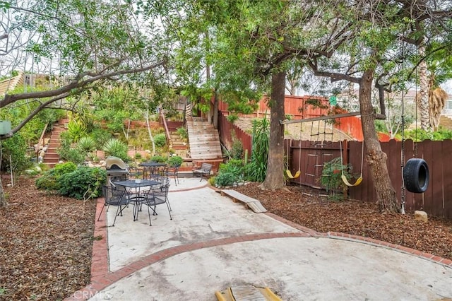 view of patio / terrace with outdoor dining area, stairs, and fence