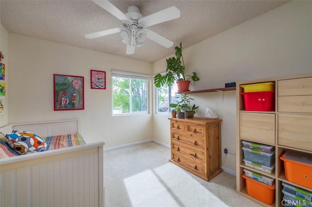 carpeted bedroom with baseboards, a ceiling fan, and a textured ceiling
