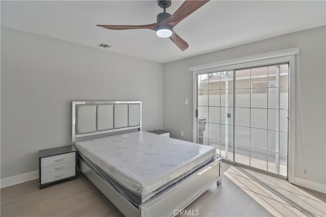 bedroom featuring visible vents, access to exterior, a ceiling fan, and wood finished floors