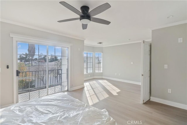 unfurnished room featuring crown molding, wood finished floors, baseboards, and a ceiling fan