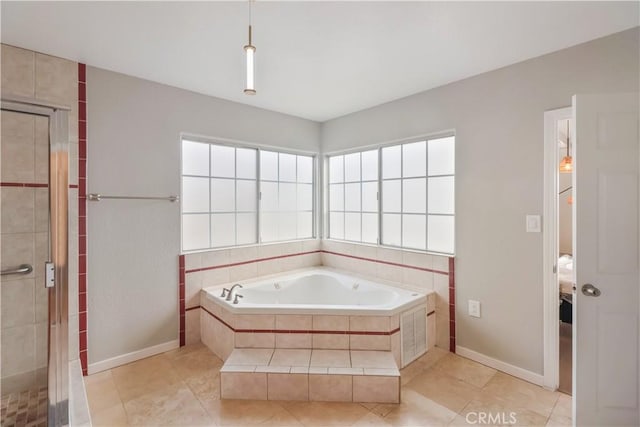 bathroom with a shower stall, plenty of natural light, baseboards, and a garden tub