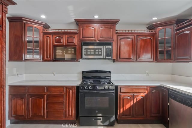 kitchen featuring stainless steel appliances, recessed lighting, glass insert cabinets, and reddish brown cabinets
