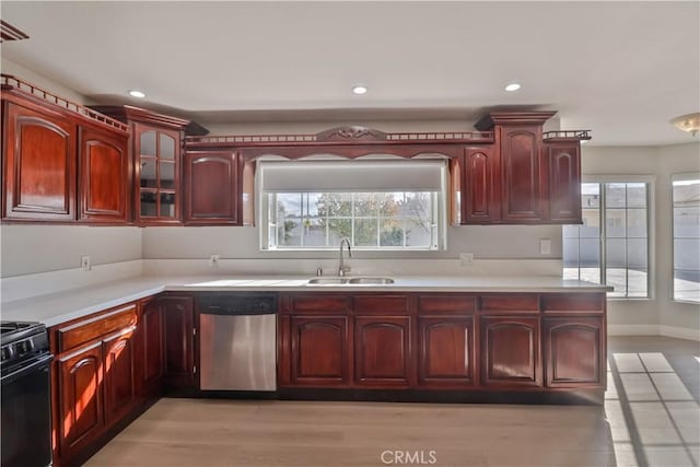kitchen with a sink, dark brown cabinets, electric range, and dishwasher