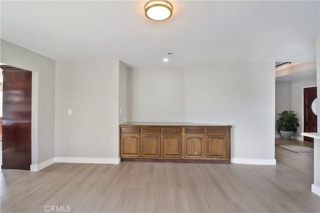 spare room with baseboards, light wood-type flooring, and recessed lighting