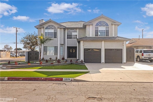 view of front facade featuring a garage, a chimney, stucco siding, a gate, and driveway