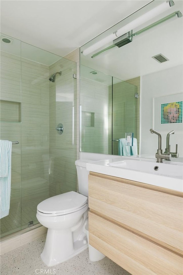 full bathroom with visible vents, a shower stall, speckled floor, vanity, and toilet