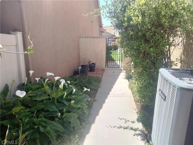 6353 Colonial Ave, Banning, CA 92220 - view of home's exterior featuring central air condition unit, stucco siding, and a gate