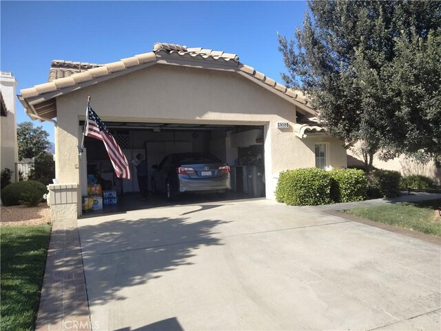 6353 Colonial Ave, Banning, CA 92220 - view of property exterior featuring driveway, an attached garage, stucco siding, and a tiled roof
