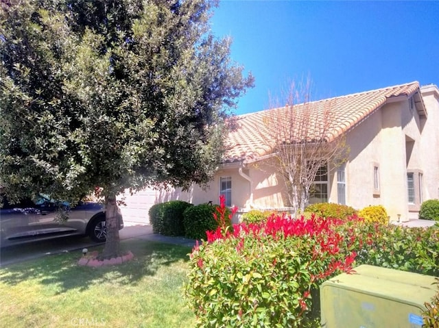 6353 Colonial Ave, Banning, CA 92220 - view of property exterior with a garage, stucco siding, a tile roof, a yard, and concrete driveway