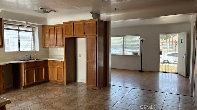 432 Oakford Dr, Los Angeles, CA 90022 - kitchen with brown cabinets, a sink, light countertops, and backsplash