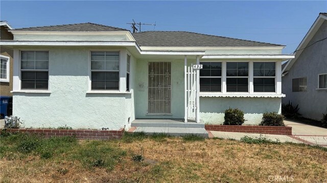 432 Oakford Dr, Los Angeles, CA 90022 - view of front of home featuring stucco siding, a front yard, and roof with shingles