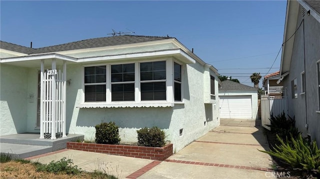 432 Oakford Dr, Los Angeles, CA 90022 - view of front of home with stucco siding, a shingled roof, an outbuilding, and a detached garage