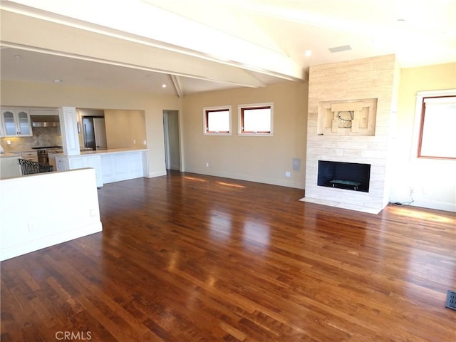 304 27th St, Manhattan Beach, CA 90266 - unfurnished living room with beamed ceiling, dark wood-style flooring, and a stone fireplace
