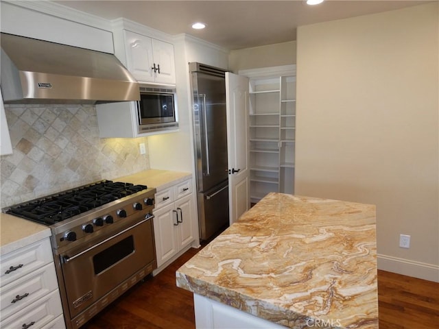 304 27th St, Manhattan Beach, CA 90266 - kitchen with high end appliances, exhaust hood, dark wood-type flooring, decorative backsplash, and white cabinets