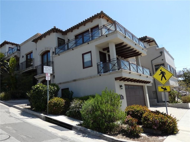 304 27th St, Manhattan Beach, CA 90266 - view of front of home with stucco siding, a garage, and a balcony