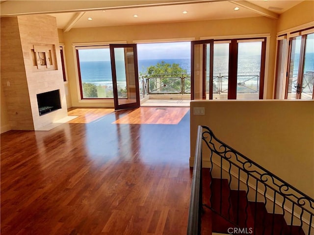 304 27th St, Manhattan Beach, CA 90266 - living room with wood finished floors, beamed ceiling, a tiled fireplace, a water view, and recessed lighting