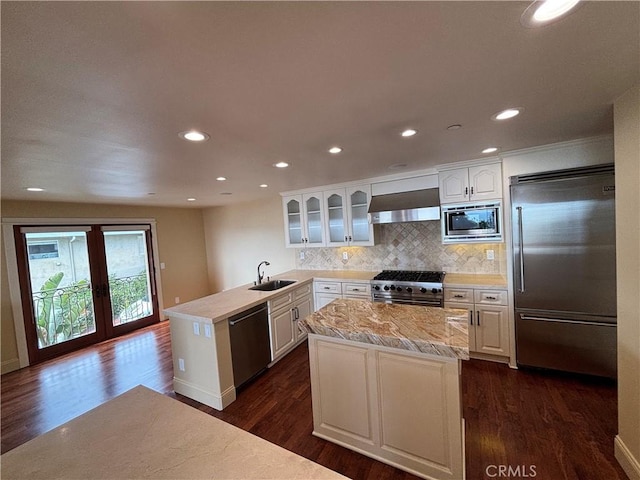 304 27th St, Manhattan Beach, CA 90266 - kitchen featuring built in appliances, a peninsula, wall chimney range hood, light countertops, and dark wood finished floors