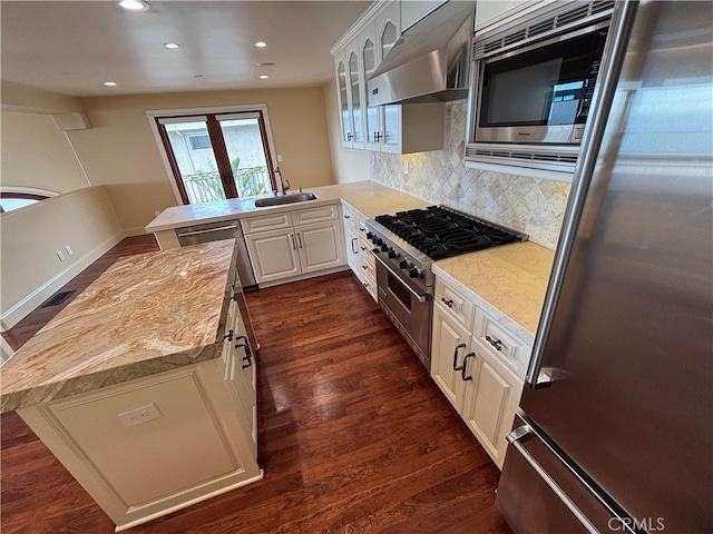304 27th St, Manhattan Beach, CA 90266 - kitchen featuring appliances with stainless steel finishes, ventilation hood, dark wood-type flooring, glass insert cabinets, and a peninsula