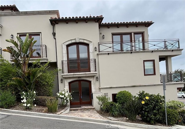 304 27th St, Manhattan Beach, CA 90266 - mediterranean / spanish-style house featuring a balcony, french doors, stucco siding, and a tiled roof