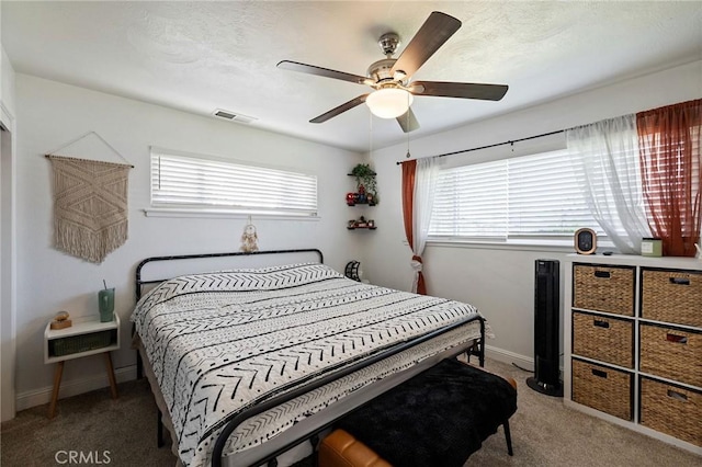 carpeted bedroom featuring visible vents, baseboards, and a ceiling fan
