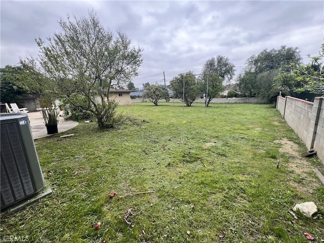 view of yard with fence and central AC