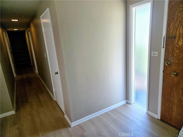 hall with light wood-type flooring and baseboards