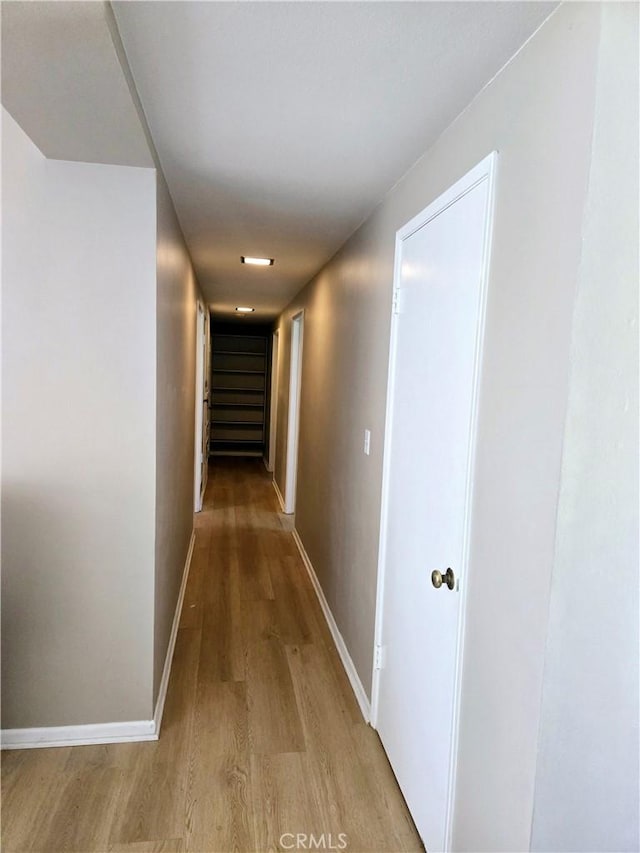 hall featuring baseboards and light wood-type flooring