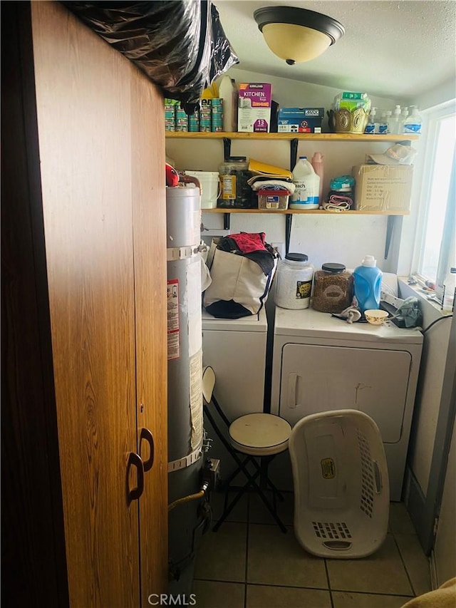 1329 W 3rd St, San Bernardino, CA 92410 - clothes washing area featuring washer and clothes dryer, tile patterned flooring, strapped water heater, and laundry area
