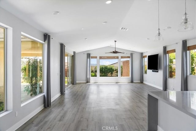 unfurnished living room featuring ceiling fan, baseboards, wood finished floors, lofted ceiling, and visible vents