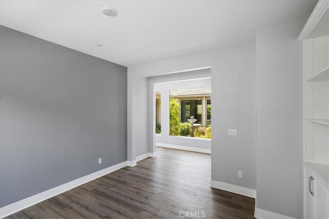 empty room with baseboards and dark wood-style flooring