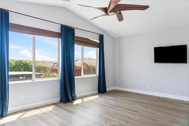 unfurnished room with baseboards, a ceiling fan, vaulted ceiling, and wood finished floors