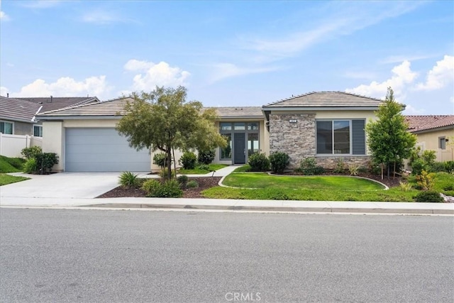 view of front of house featuring fence, stone siding, a garage, a front yard, and driveway