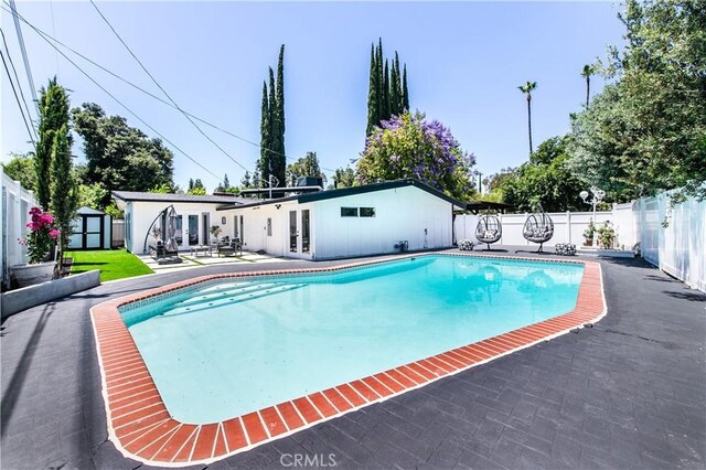 22838 Epsilon St, Woodland Hills, CA 91364 - view of pool featuring french doors, a fenced backyard, a shed, a patio, and an outbuilding