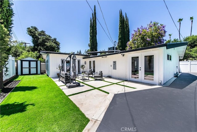 22838 Epsilon St, Woodland Hills, CA 91364 - rear view of property featuring french doors, a patio, a storage shed, board and batten siding, and an outbuilding
