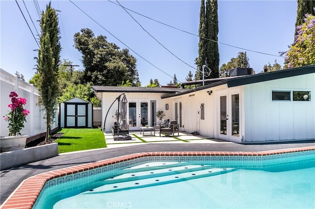 22838 Epsilon St, Woodland Hills, CA 91364 - rear view of house featuring french doors, a storage shed, a patio area, board and batten siding, and an outdoor pool