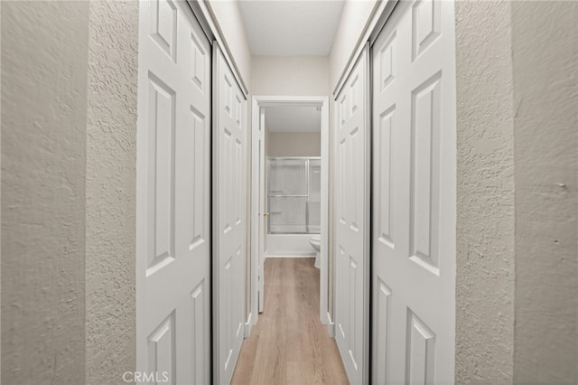 26497 Calle San Francisco Unit 60F, San Juan Capistrano, CA 92675 - hallway featuring a textured wall, light wood finished floors, and a textured ceiling