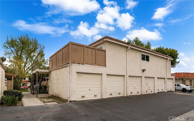26497 Calle San Francisco Unit 60F, San Juan Capistrano, CA 92675 - view of property exterior featuring community garages, stairs, and stucco siding
