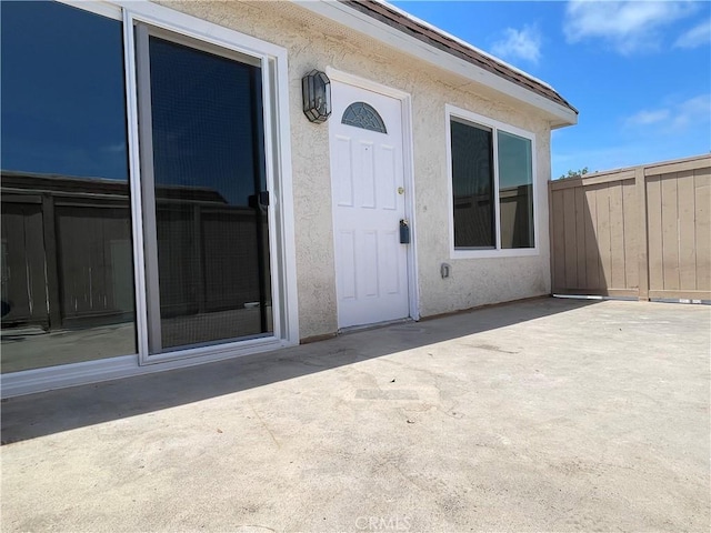 26497 Calle San Francisco Unit 60F, San Juan Capistrano, CA 92675 - view of exterior entry with fence, stucco siding, and a patio area