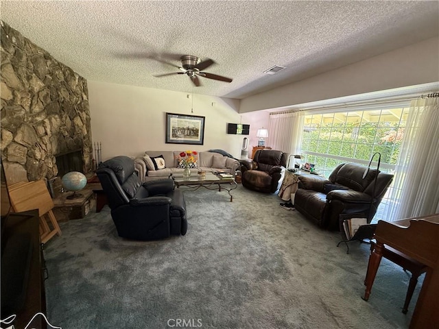 living room featuring a textured ceiling, carpet flooring, ceiling fan, and visible vents