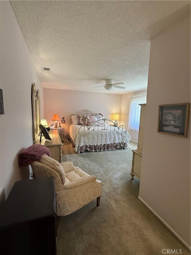 carpeted bedroom featuring visible vents, a textured ceiling, baseboards, and ceiling fan