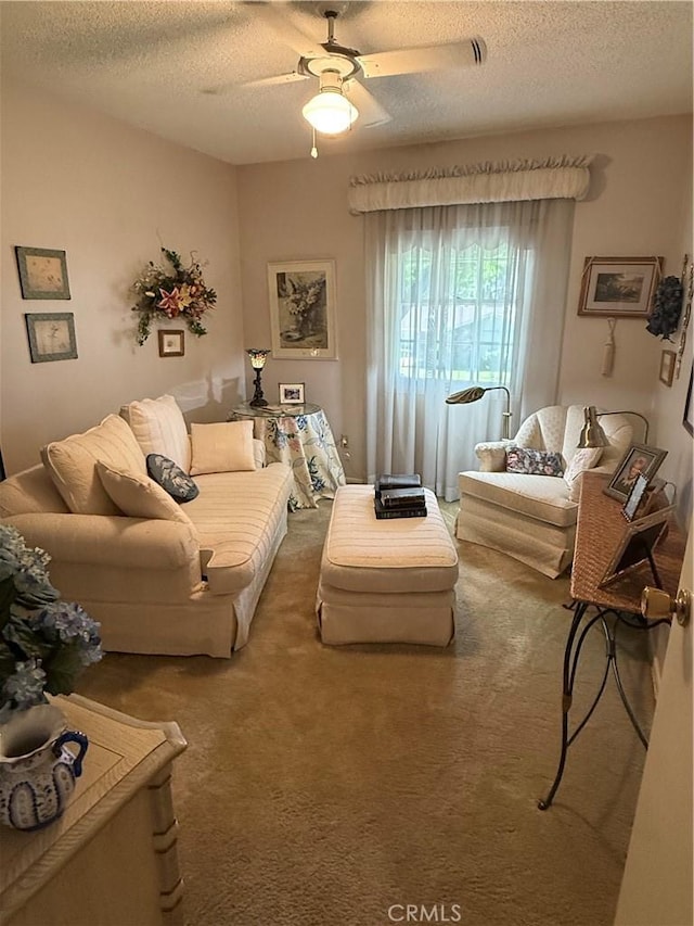 living room with a textured ceiling, ceiling fan, and carpet floors