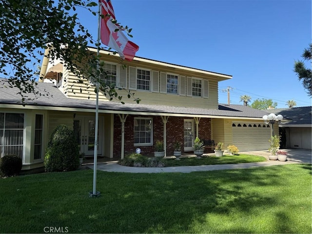 traditional home with a garage, a front yard, driveway, and french doors