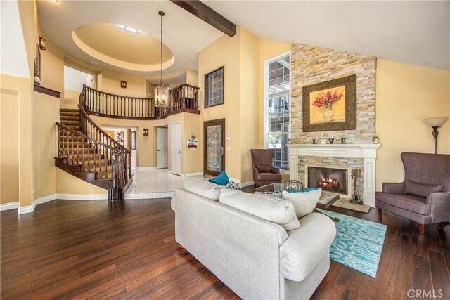 880 E 24th St, Upland, CA 91784 - living area with a stone fireplace, wood-type flooring, high vaulted ceiling, stairway, and baseboards