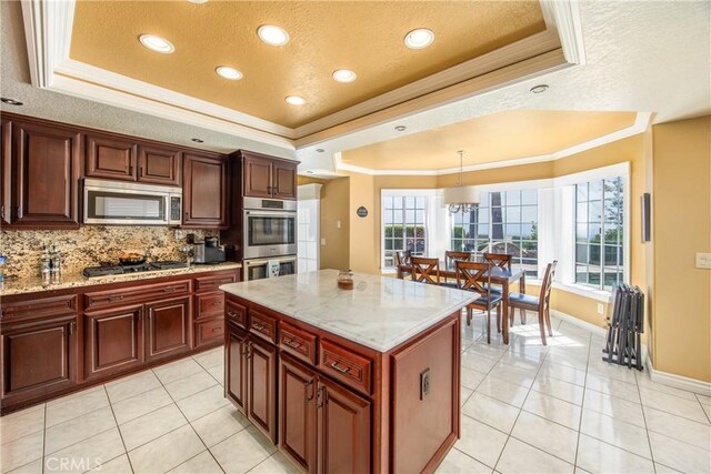 880 E 24th St, Upland, CA 91784 - kitchen featuring a tray ceiling, appliances with stainless steel finishes, crown molding, tasteful backsplash, and light tile patterned floors